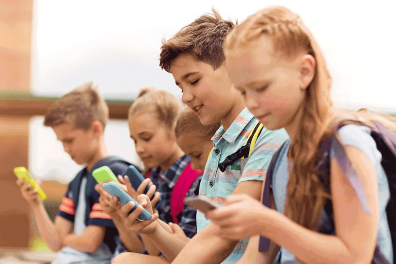 Crianças usando celular na escola.