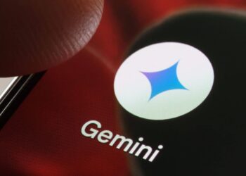 Ícone do aplicativo Gemini na tela de um smartphone com um dedo se aproximando.