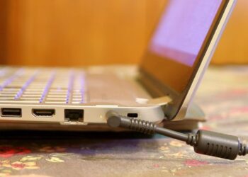 Vista lateral de um Notebook com cabo de carregamento conectado